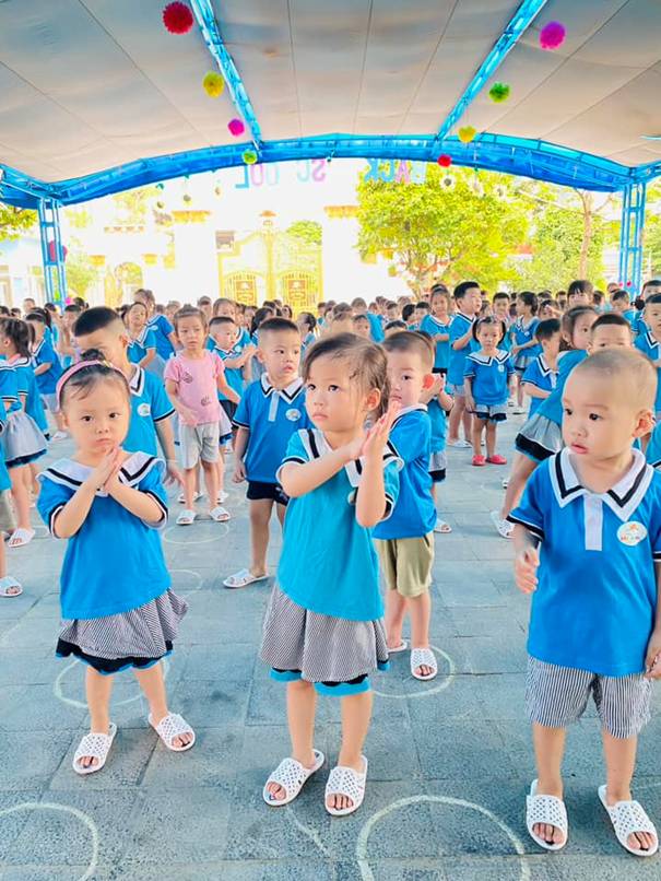 A group of children in blue shirts

Description automatically generated